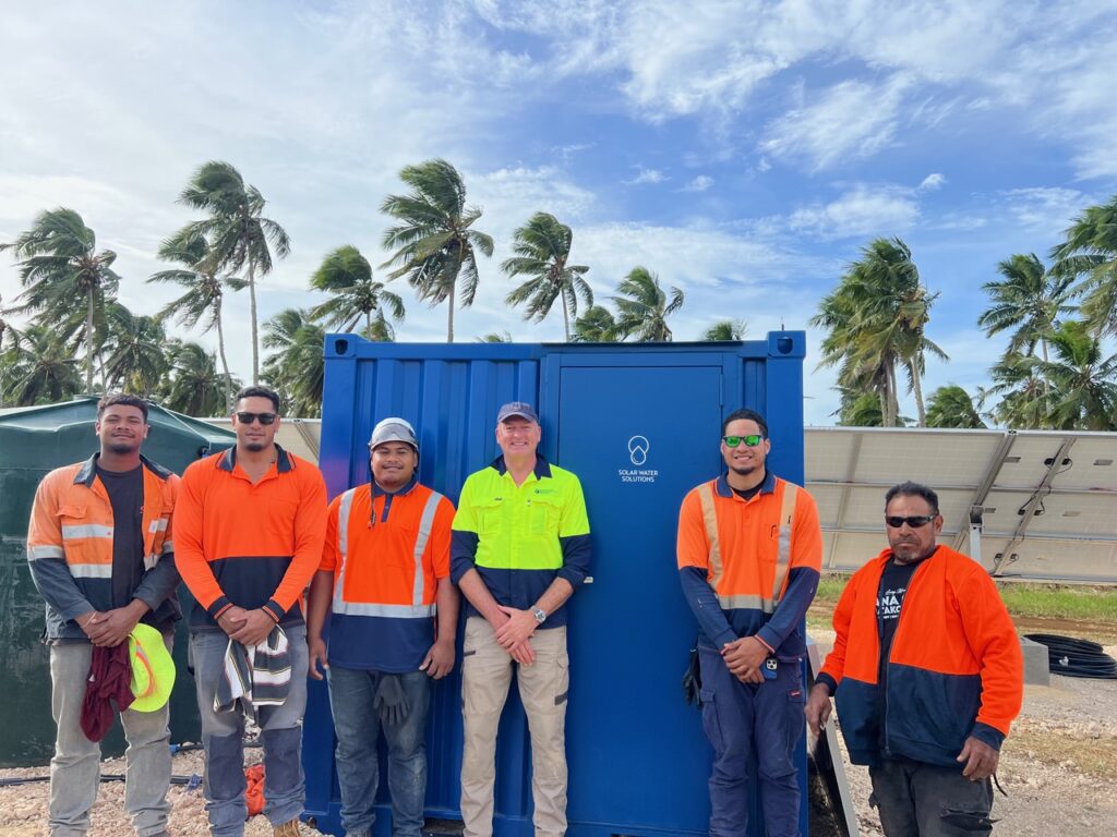 Installation and service team in front of a SolarRO desalination system in Tonga